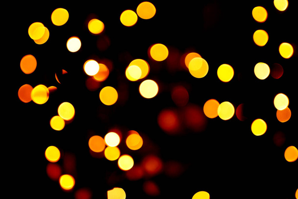 Bokeh. garland lights on a dark background. Christmas decoration.  - Foto, afbeelding