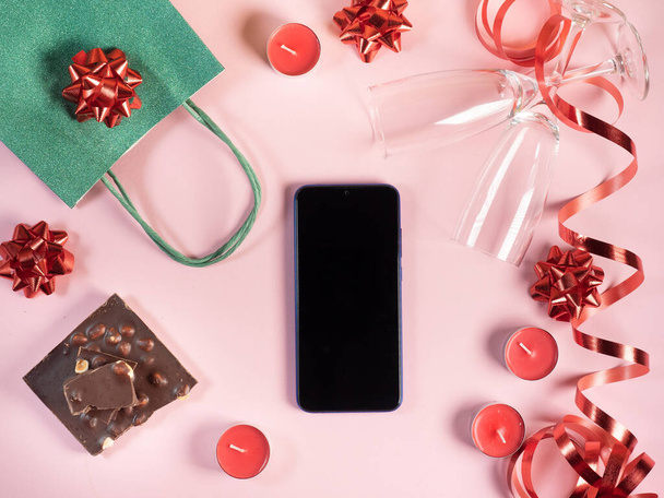 Smartphone mockup Valentines Day background. Gift, candles, glasses on pink background - Foto, Bild