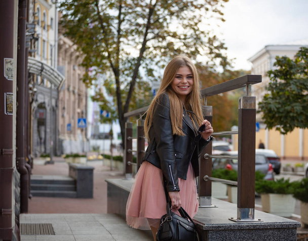Hermosa chica sonriente en la calle de una ciudad moderna - Foto, Imagen