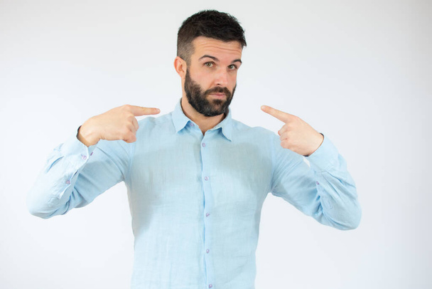 Young man wearing casual blue shirt pointing mouth with fingers over white background. - Photo, Image