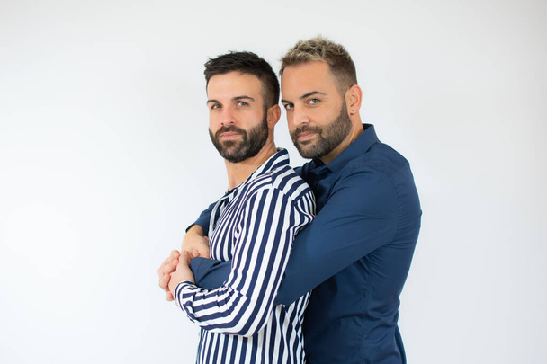 Νέοι γκέι δύο άντρες που φοράνε καθημερινά ρούχα αγκαλιάζονται χαρούμενοι και θετικοί, χαμογελαστοί με αυτοπεποίθηση. αυτοαγάπη και αυτοφροντίδα - Φωτογραφία, εικόνα