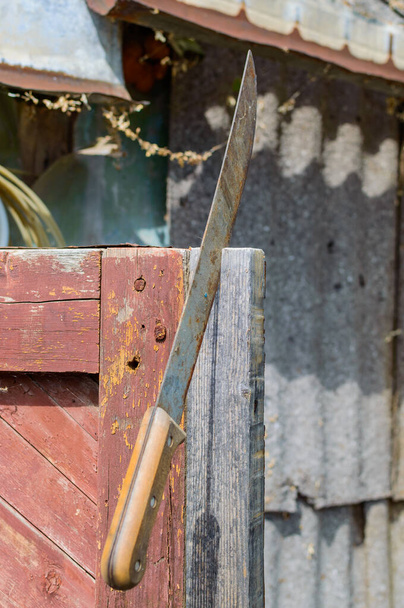 Machete oxidado viejo grande pegado en la construcción de madera para la seguridad. - Foto, Imagen