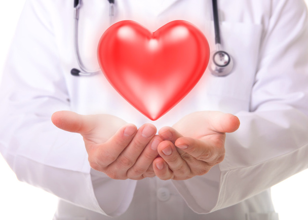 Male doctor showing a red heart - Foto, afbeelding