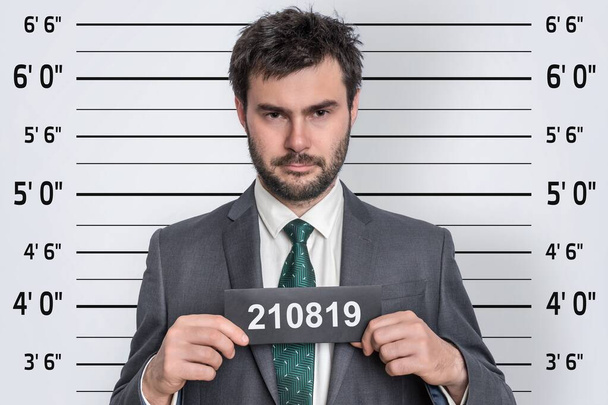 Магшот человека в костюме в полицейском участке - концепция идентификации заключенного - Фото, изображение