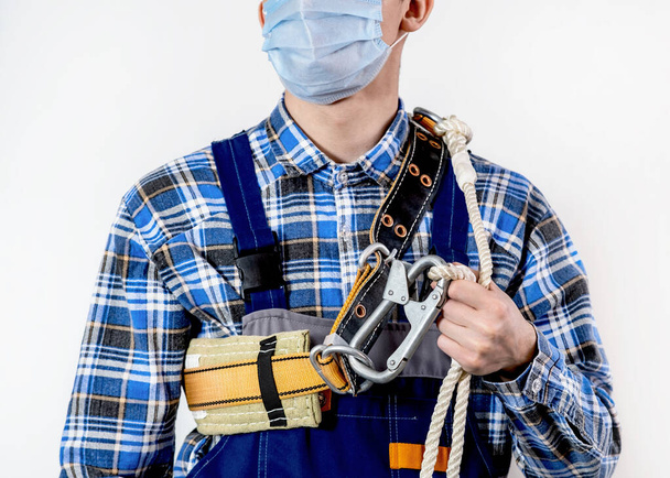 Seat belt on the employees shoulders. Safety belt with a carabiner and a supply of rope. - Foto, immagini