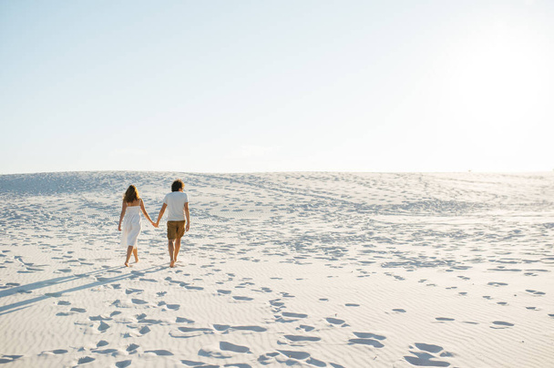 Vacation couple walking on beach together in love holding around each other. - Foto, Imagen