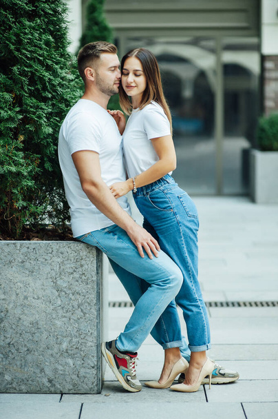 Fashion outdoor romantic portrait of beautiful young couple in love and hugs on the street. - Photo, Image