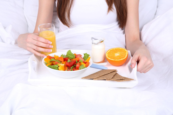 Mujer en la cama con desayuno ligero
  - Foto, Imagen