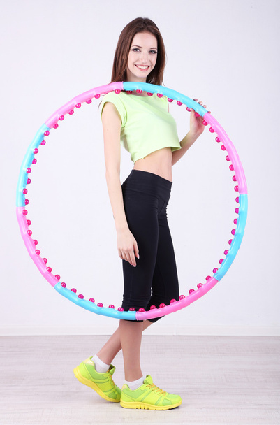 Woman doing exercises with hula hoop in room - Photo, Image