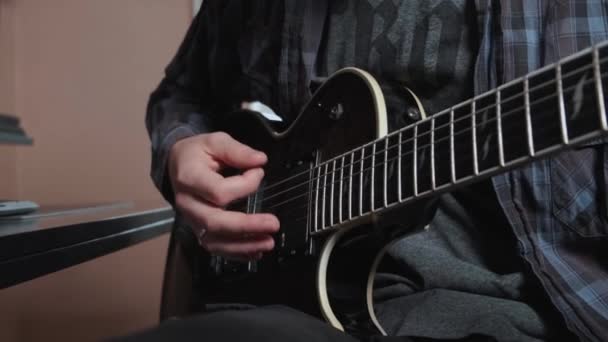 close-up van mannelijke hand spelen elektrische gitaar. - Video