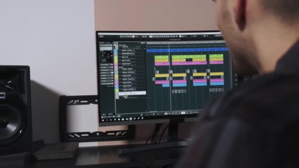 De muzikant werkt op een computer en creëert een muzikale compositie. - Video