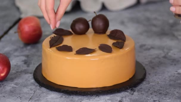 Pastelero decorando el pastel de mousse con pequeñas piezas de chocolate. Pastelero decorado Moderno pastel europeo. - Metraje, vídeo