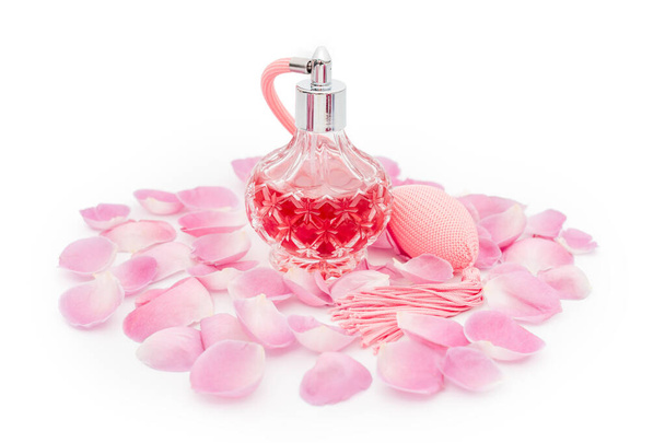 Parfüm palack virágszirmokkal fehér alapon. Illatszerek, kozmetikumok, illatanyagok gyűjtése. - Fotó, kép