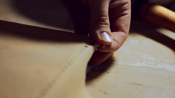 De hand van de vrouw scheidt de snijkant van het deeg na het gebruik van ravioli wielsnijder. Proces van de bereiding van ravioli thuis. 4K video, close-up - Video
