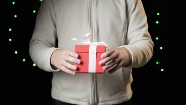 Childs kädet antaa punainen laatikko valkoinen nauha. joulu, uusi vuosi käsite - Materiaali, video