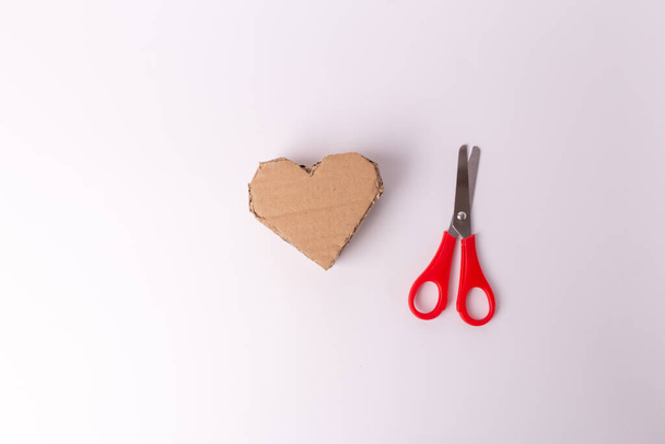recycled cardboard heart shape craft, red scissors - Foto, imagen