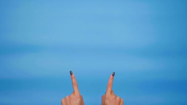 Vrouw handen wijzend op kopieerruimte, duimen omhoog, zoals op blauwe achtergrond - Video