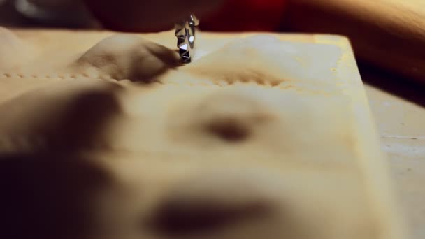 Primer plano de la mano de las mujeres utilizando el cortador de rueda de ravioles para cortar la masa con relleno de carne en el interior. Preparación de ravioles, un plato típico italiano, hecho en casa según la antigua tradición italiana. Vídeo 4K. - Imágenes, Vídeo