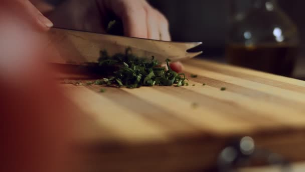 Pilkkovat vihreää persiljaa veitsellä puisella leikkuulaudalla. Terveellinen ainesosa herkulliseen ravioliin. Raviolin valmistusprosessi. 4K-video - Materiaali, video