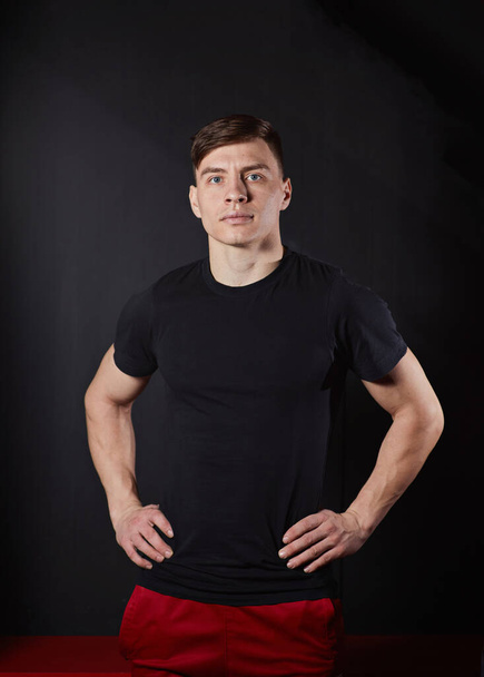 Handsome young muscular man looking at camera in studio shot over neutral background - Фото, изображение