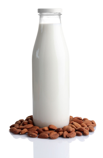 Almond milk in bottle with almonds, isolated on white - Fotoğraf, Görsel