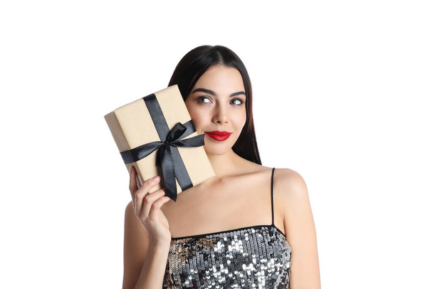 Woman in party dress holding Christmas gift on white background - Foto, Bild