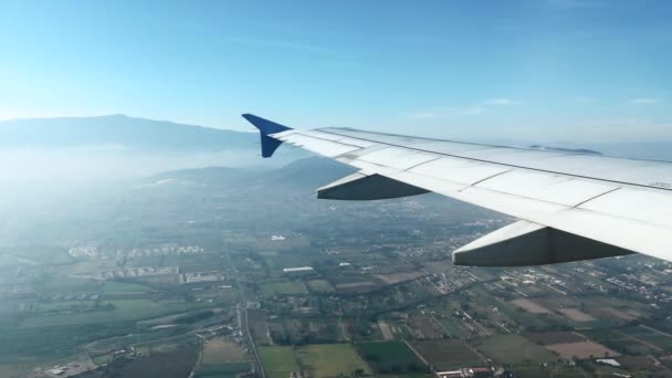 Vista 4k del ala del avión sobrevolando la ciudad mexicana de Guadalajara en un día soleado - Metraje, vídeo