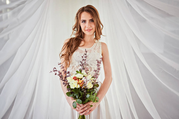 όμορφο τρυφερό γαμήλιο μπουκέτο από κρεμ τριαντάφυλλα και άνθη ευστώματος στα χέρια της νύφης - Φωτογραφία, εικόνα
