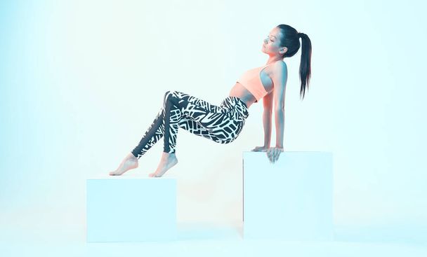Sporty girl posing in sport clothes in neon light. Fit young model with perfect body shapes. Healthy lifestyle, diet - 写真・画像