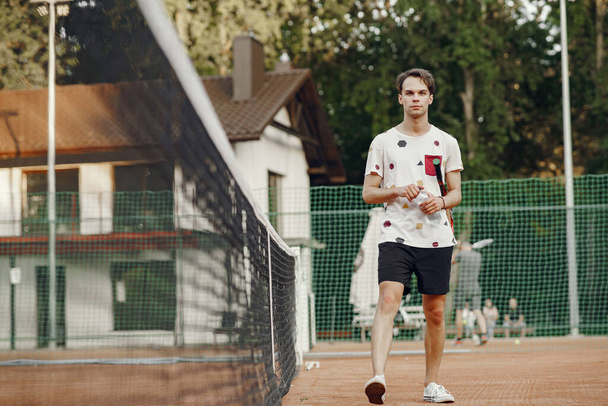 Handsome man in a summer tennis court - Foto, Imagem