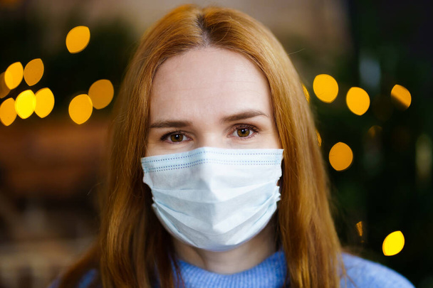 portrait of a woman in a disposable protective medical mask. garland lights. - Photo, Image