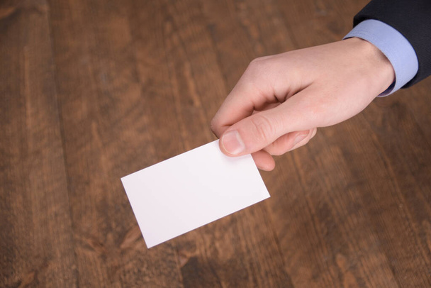 Рука тримає порожній макет білої картки з закругленими кутами. Звичайна картка виклику маскує шаблон, що тримає руку. Передній дисплей пластикової кредитної картки. Перевірте дизайн офсетних карток. Брендинг бізнесу
 - Фото, зображення