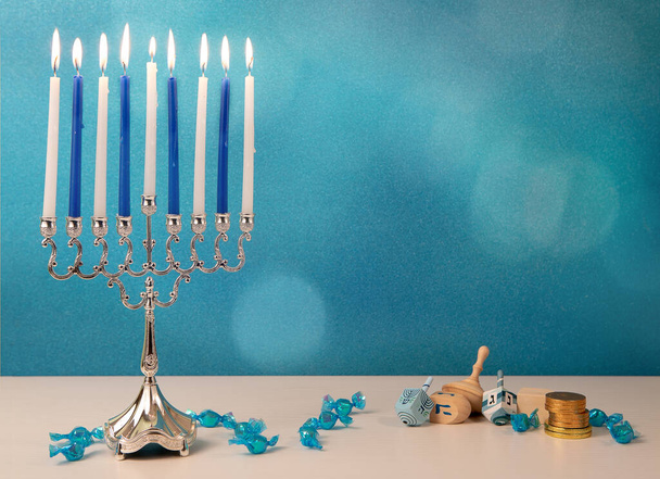 concepto de día de fiesta religiosa judía hanukkah con juguetes de madera dreidel, tradicional araña menorah y monedas de chocolate - Foto, imagen