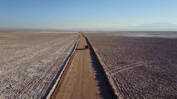 Punainen avolava-auto ajaa Atacaman autiomaan läpi Chilessä. - Materiaali, video