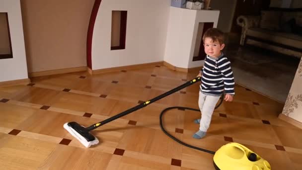 L'enfant lave le sol. Nettoyage de maison enfant. Vidéo de haute qualité - Séquence, vidéo