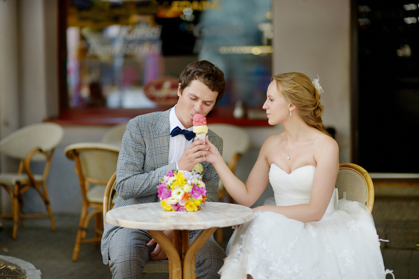 Bride and groom having an ice cream outdoors - Foto, afbeelding