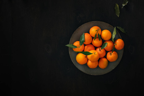 a plate of tangerines on a wooden table. top view.Christmas mood . High quality photo - Foto, imagen