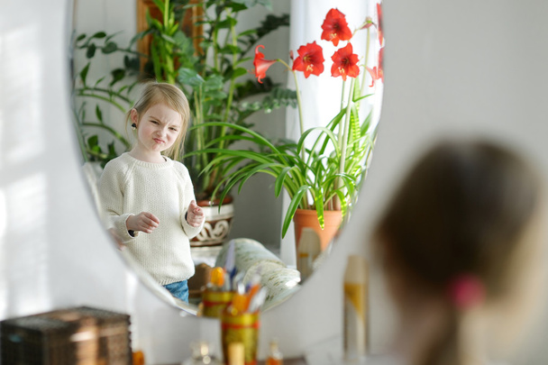 Funny girl looking at herself in a mirror - Fotoğraf, Görsel