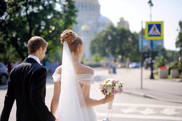 Bride and groom walking across the street - Photo, image