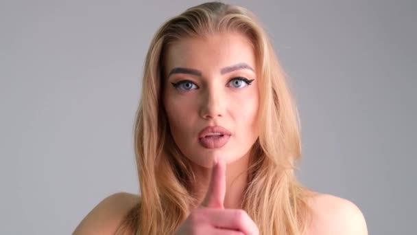Bella giovane donna bionda sensuale copre le labbra sexy rosse con il dito che mostra silenzio nella notte ritratto all'aperto - Filmati, video