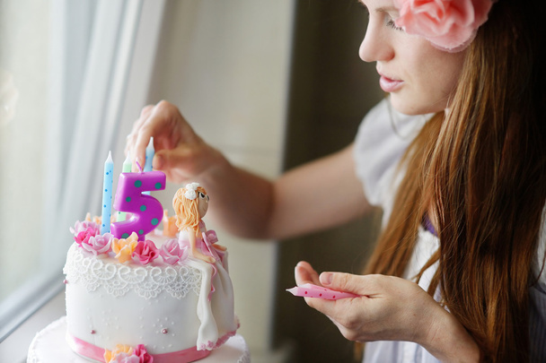 Young mother decorating daughters birhtday cake - Foto, Imagen