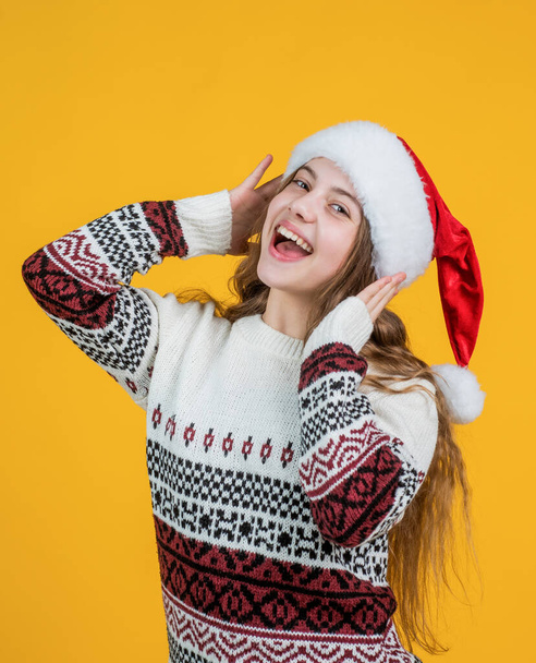 so happy. party fun. prepare for winter holiday. happy new year. merry christmas. cheerful teen girl celebrate xmas party. kid wear red santa claus hat. child santa helper in knitted sweater - Photo, image