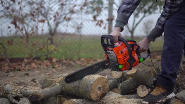 Lubmerjack serrar troncos de árvores com motosserra. Trabalhador agricultor fazendo tarefas domésticas - Filmagem, Vídeo