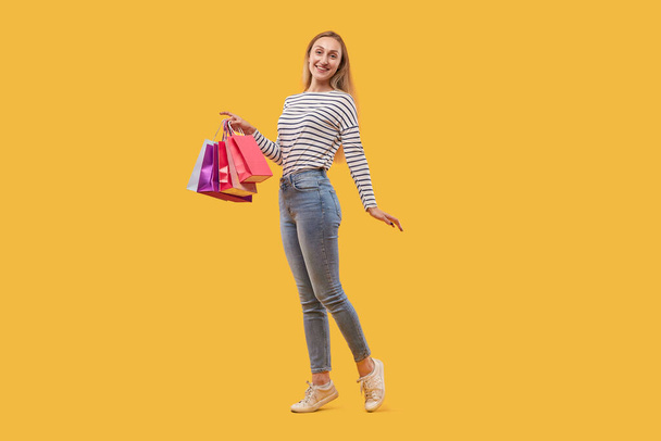 Happy beautiful young blonde woman with shopping bags in her hands. - Photo, Image