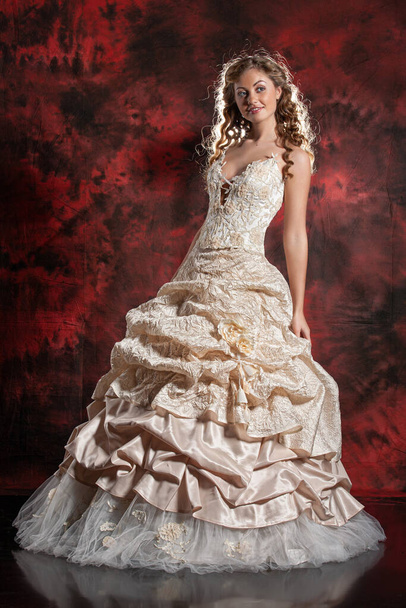 Young beautiful woman in a wedding dress on a studio background - Fotografie, Obrázek