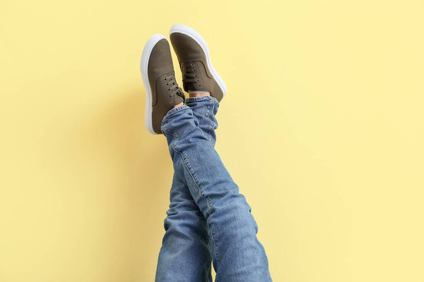 Young man in stylish shoes on color background - Foto, immagini