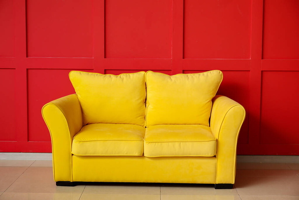 Stylish sofa near color wall in room - Fotó, kép