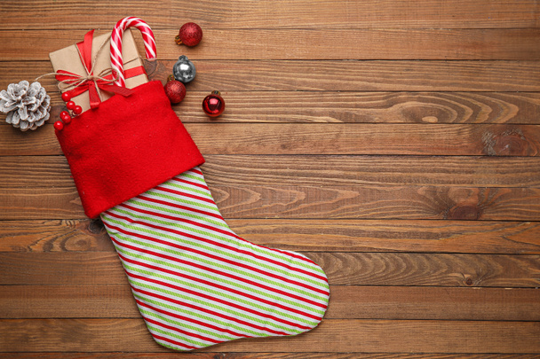 Christmas sock with gifts on wooden background - Photo, Image