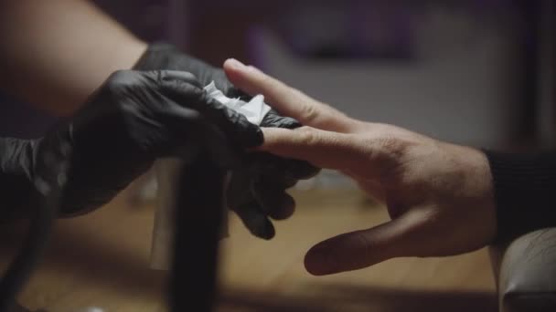 Mies laitteisto manikyyri - kynsien mestari pyyhkii pois kynsien pölyä käsistään asiakkaansa - Materiaali, video