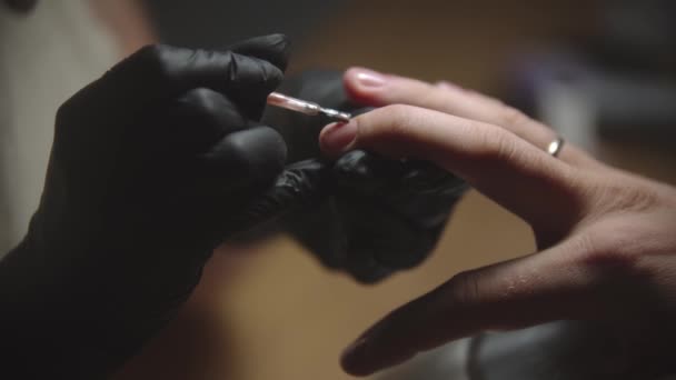Mężczyzna manicure - mistrz paznokci stosujący beżowy lakier do paznokci na płytce paznokci - Materiał filmowy, wideo